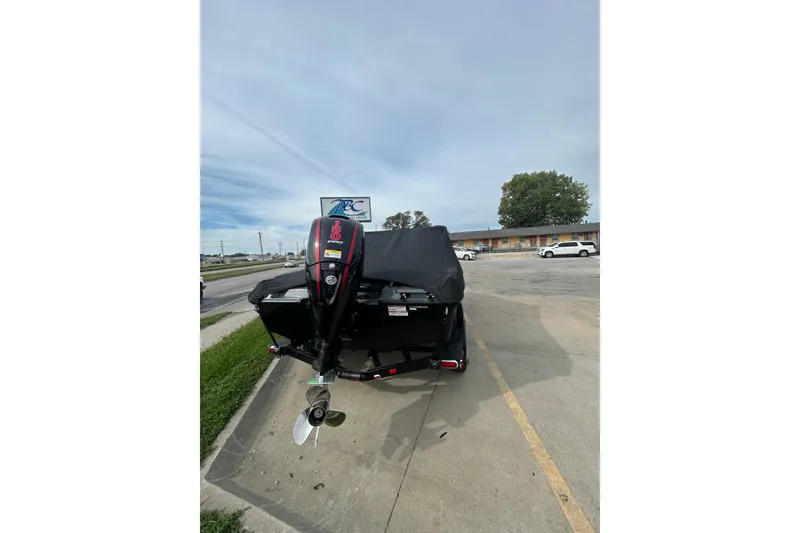 Slide: The Image of 2026 Lund 185 Impact GL boat with covered motor in parking lot. - 11