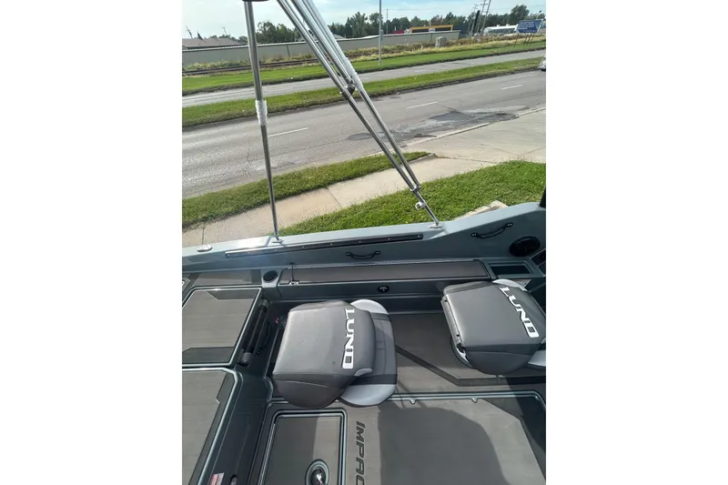 Slide: The Image of 2026 Lund 185 Impact GL boat interior with seats and rod holders. - 12