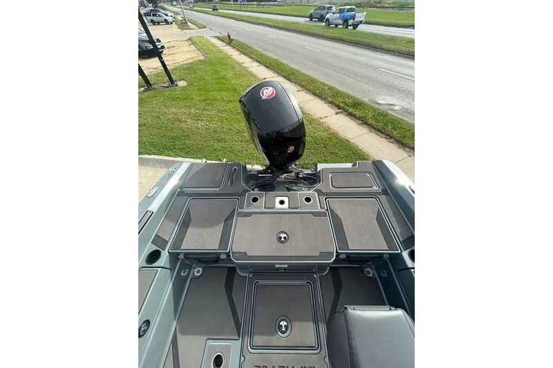 Slide: The Image of 2026 Lund 185 Impact GL boat with sleek deck design and powerful outboard motor. - 14