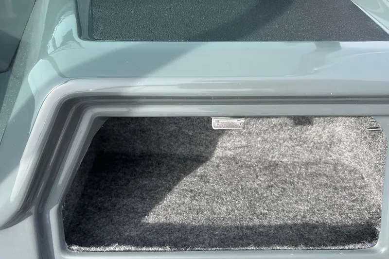 Slide: The Image of Storage compartment of 2026 Lund 185 Impact GL boat, featuring carpeted interior. - 20
