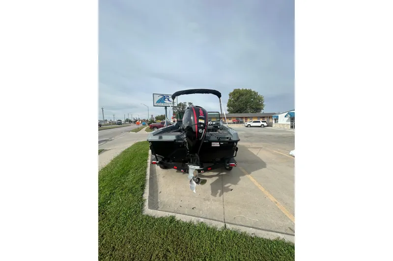 Slide: The Image of 2026 Lund 185 Impact GL boat parked on a street, rear view. - 8