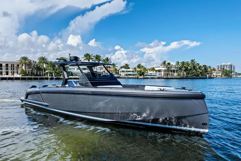 Slide: The Image of 2024 Vanquish Yachts 40 on serene water with luxury waterfront homes in the background. - 11