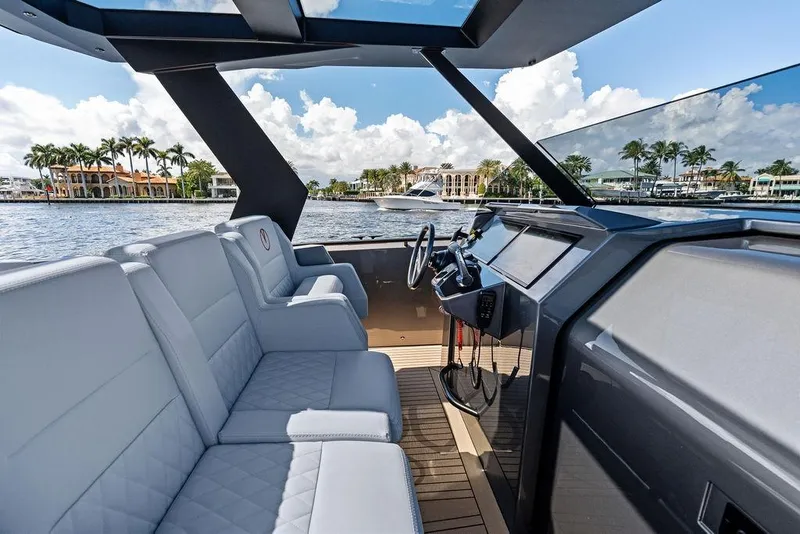 Slide: The Image of 2024 Vanquish Yachts 40 interior with luxurious seating and modern dashboard on a sunny day. - 19