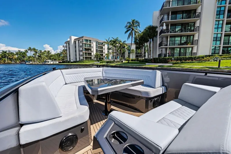 Slide: The Image of Luxurious 2024 Vanquish Yachts 40 with elegant seating, docked near waterfront apartments. - 22