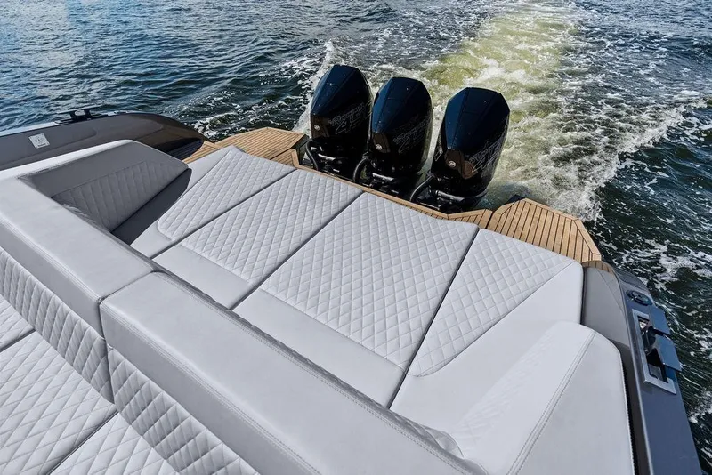 Slide: The Image of 2024 Vanquish Yachts 40 with luxurious seating and triple outboard motors on water. - 25
