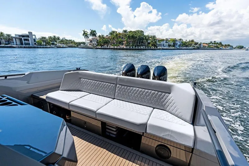 Slide: The Image of 2024 Vanquish Yachts 40 with luxurious seating, cruising on a scenic waterway. - 28