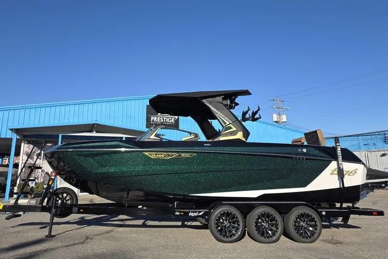 The Image of 2026 Tigé 25ZX boat on trailer, parked outside a blue building under clear sky. - 1