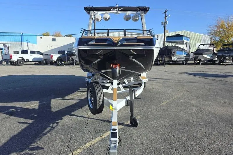 Slide: The Image of 2026 Tigé 22RZX boat on trailer in parking lot, surrounded by vehicles and buildings. - 7