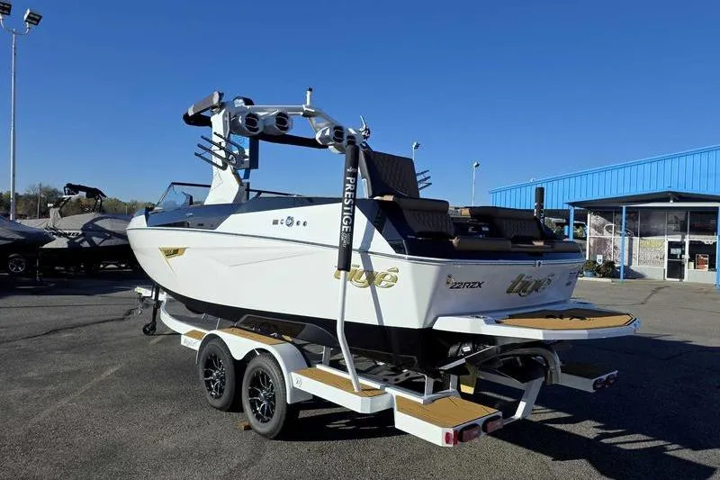 Slide: The Image of 2026 Tigé 22RZX boat on trailer, displayed outdoors under clear blue sky. - 8