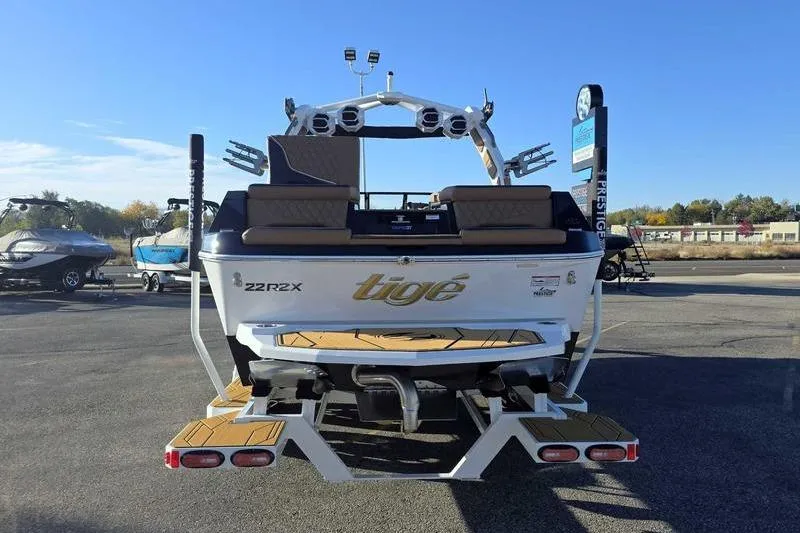 Slide: The Image of 2026 Tigé 22RZX boat, rear view, parked outdoors on a sunny day. - 9