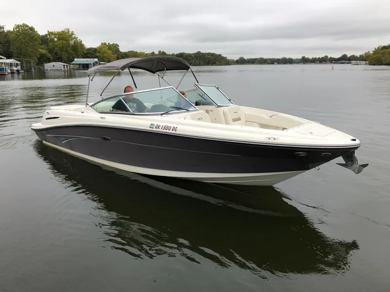 The Image of 2006 Sea Ray 270 SLX boat docked at a marina, reflecting on calm water. - 0