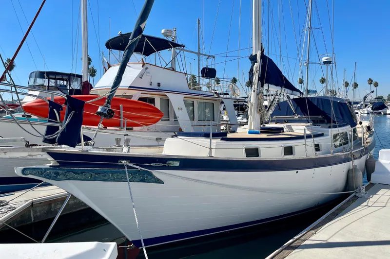 Slide: The Image of 1978 Downeast 38 sailboat docked in marina, featuring classic design and blue accents. - 0