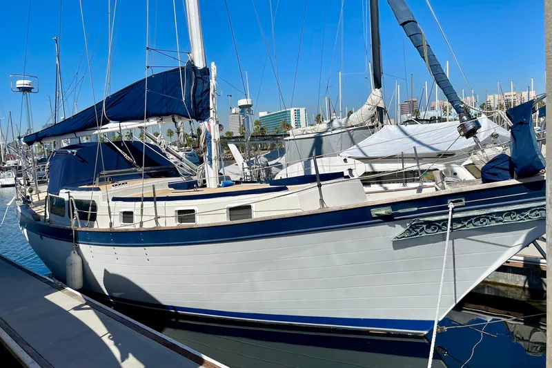 Slide: The Image of 1978 Downeast 38 sailboat docked in a marina under clear blue skies. - 1
