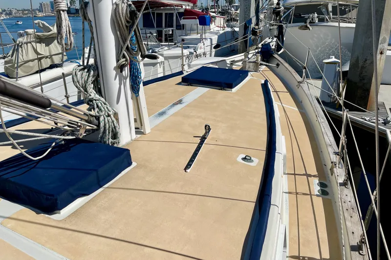 Slide: The Image of 1978 Downeast 38 sailboat deck with ropes and blue cushions at marina. - 15