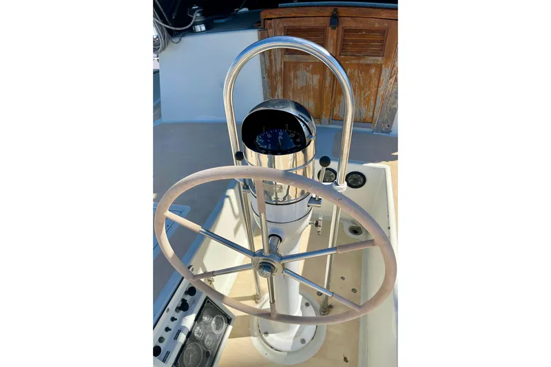 Slide: The Image of Steering wheel and compass of a 1978 Downeast 38 sailboat cockpit. - 16