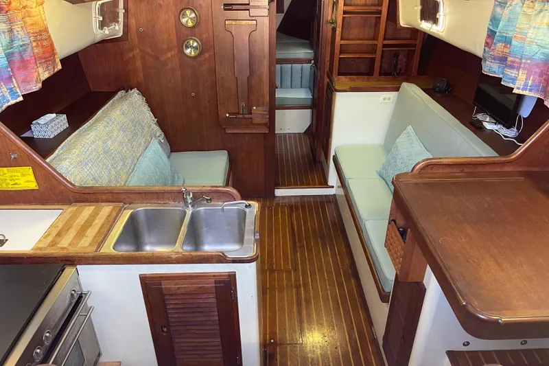 Slide: The Image of 1978 Downeast 38 yacht interior with wood finish, kitchenette, and seating area. - 19