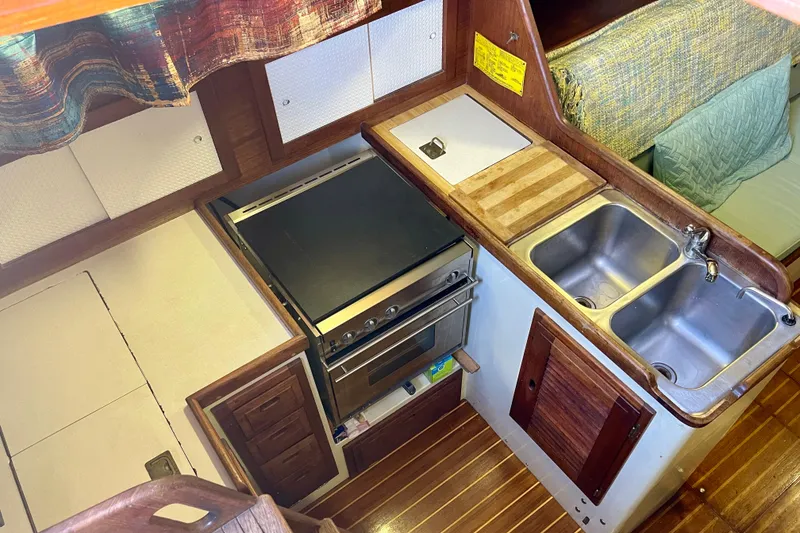 Slide: The Image of 1978 Downeast 38 yacht kitchen with stove, double sink, and wooden cabinetry. - 20