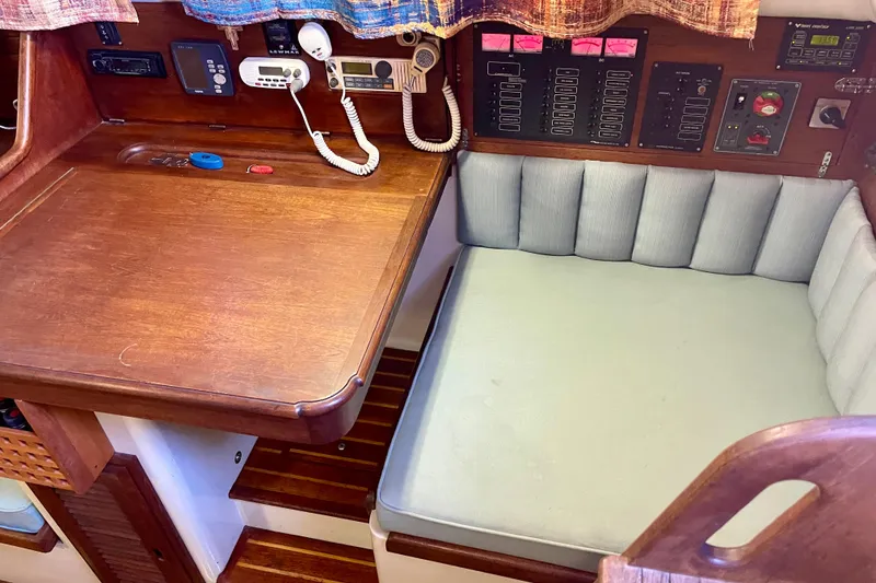 Slide: The Image of 1978 Downeast 38 sailboat interior with navigation station and cushioned seating area. - 21