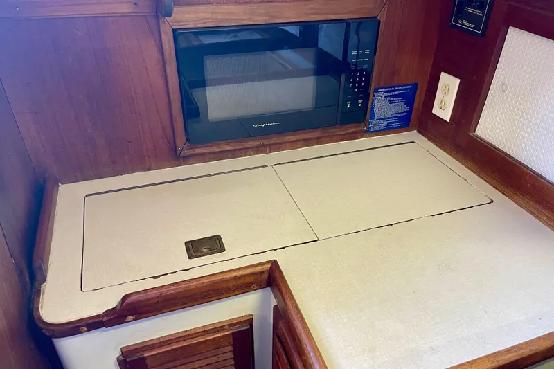 Slide: The Image of 1978 Downeast 38 yacht interior with microwave and countertop in wooden cabinetry. - 24