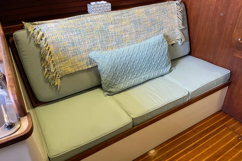 Slide: The Image of 1978 Downeast 38 interior with cushioned seating, decorative throw, and wooden flooring. - 27