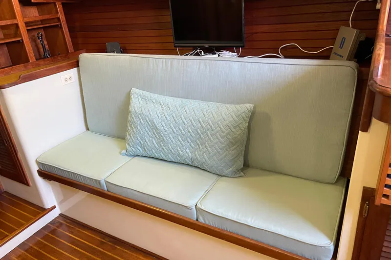 Slide: The Image of 1978 Downeast 38 interior with light blue cushioned seating and wooden accents. - 29