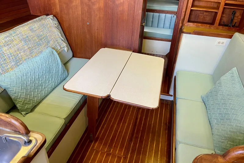 Slide: The Image of 1978 Downeast 38 yacht interior with wooden flooring and cozy seating area. - 31