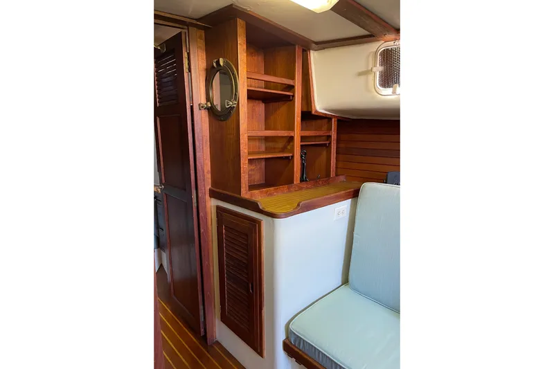 Slide: The Image of 1978 Downeast 38 yacht interior with wooden shelves and seating area. - 32