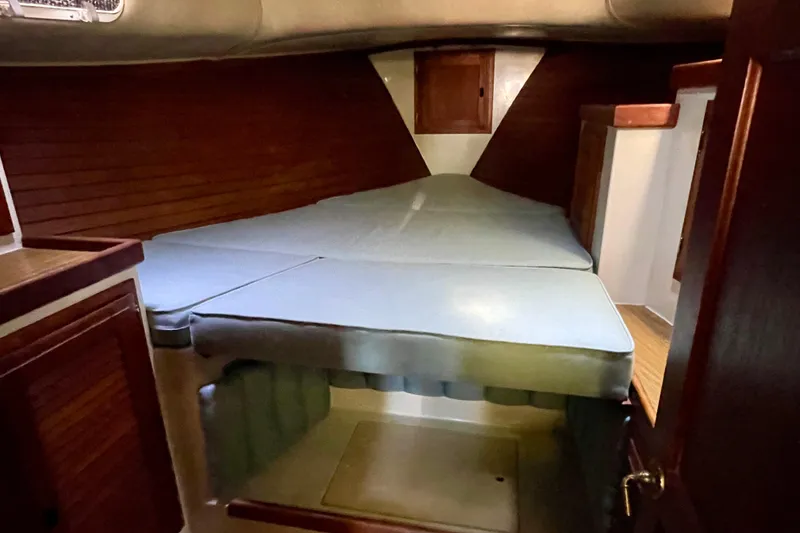 Slide: The Image of Cozy cabin interior of 1978 Downeast 38 sailboat with wooden accents and cushioned berth. - 34