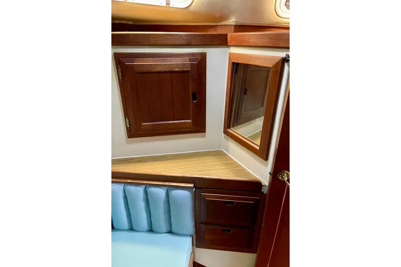 Slide: The Image of 1978 Downeast 38 yacht interior with wooden cabinets and blue cushioned seating. - 36