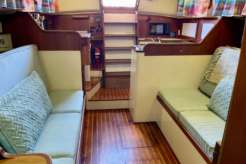 Slide: The Image of Interior of a 1978 Downeast 38 sailboat with cozy seating and wooden flooring. - 39