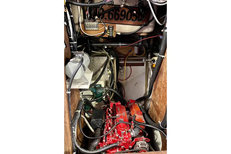 Slide: The Image of Engine compartment of a 1978 Downeast 38 boat, featuring a red engine and wiring. - 40