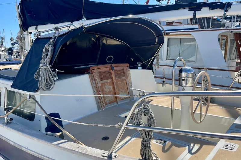 Slide: The Image of 1978 Downeast 38 sailboat with blue canopy and wooden hatch in marina. - 5