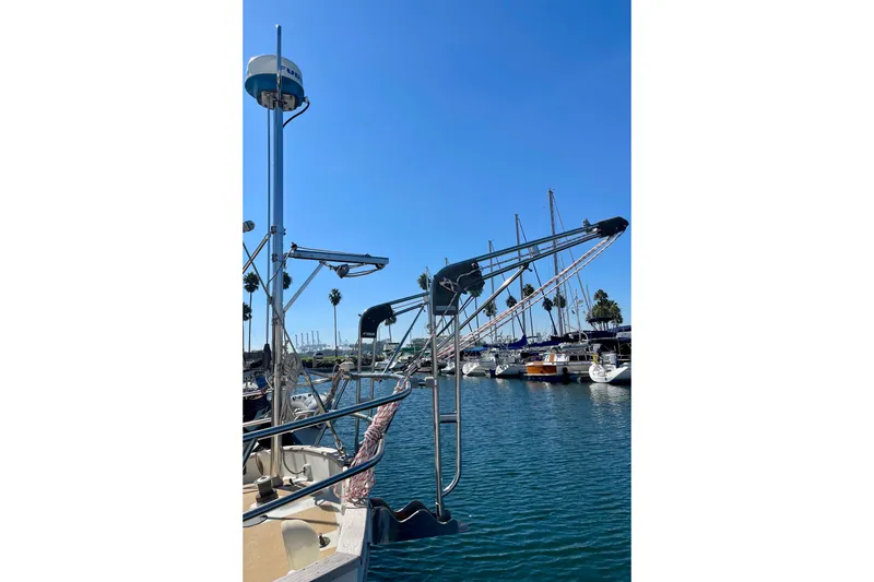 Slide: The Image of 1978 Downeast 38 sailboat docked in a sunny marina with clear blue skies. - 7