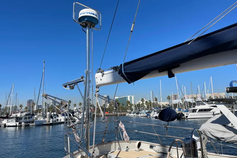 Slide: The Image of 1978 Downeast 38 sailboat in marina, clear blue sky, masts, and cityscape background. - 8