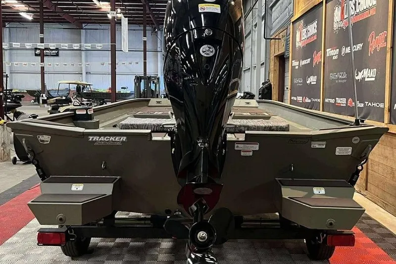 Slide: The Image of 2026 Tracker Grizzly 2072 CC boat in showroom, rear view with motor. - 3