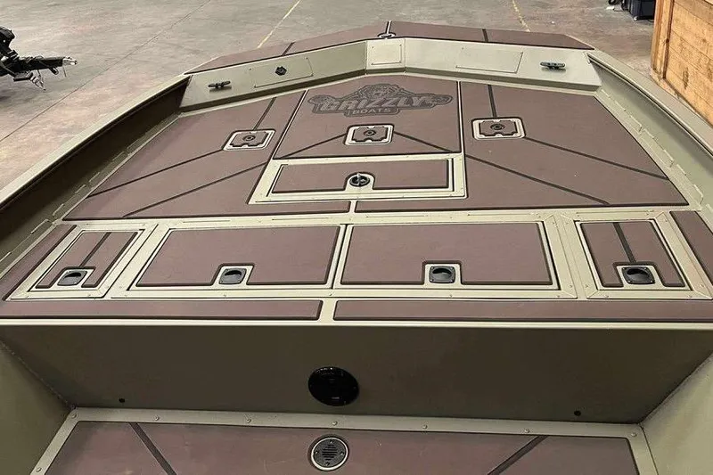 Slide: The Image of 2026 Tracker Grizzly 2072 CC boat deck with storage compartments, brown and beige design. - 4