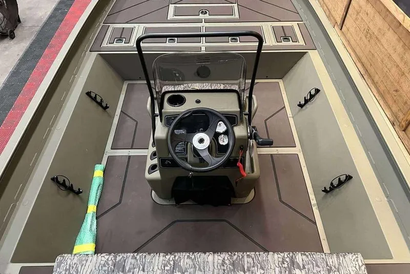 Slide: The Image of 2026 Tracker Grizzly 2072 CC boat interior with steering console and rod holders. - 5