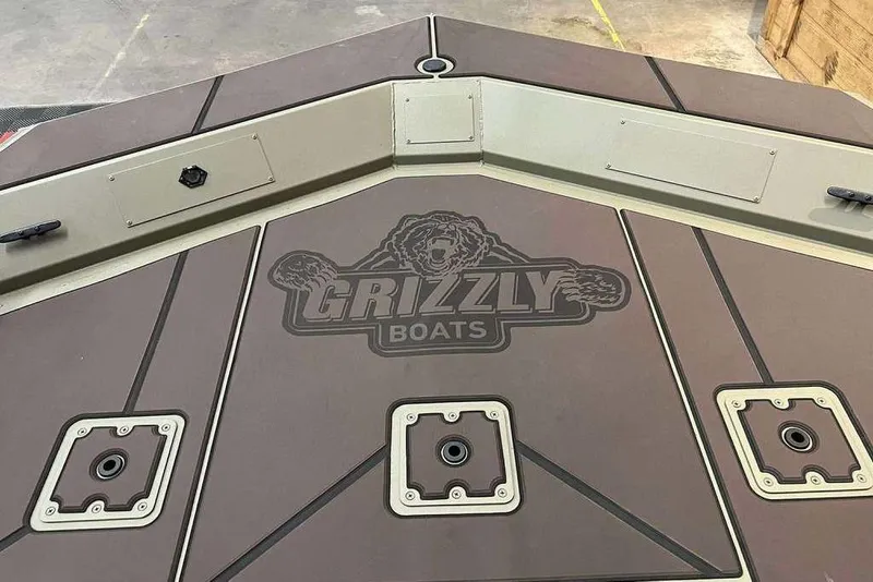 Slide: The Image of 2026 Tracker Grizzly 2072 CC boat deck with logo and storage compartments. - 7