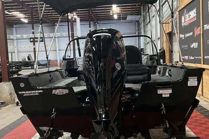 Slide: The Image of 2026 Tracker Pro Guide V-16 WT boat in showroom, rear view with motor. - 3