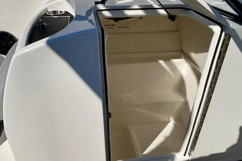 Slide: The Image of 2026 Bayliner VR6 Bowrider I/O storage compartment, open and empty, with sunlight casting shadows. - 11
