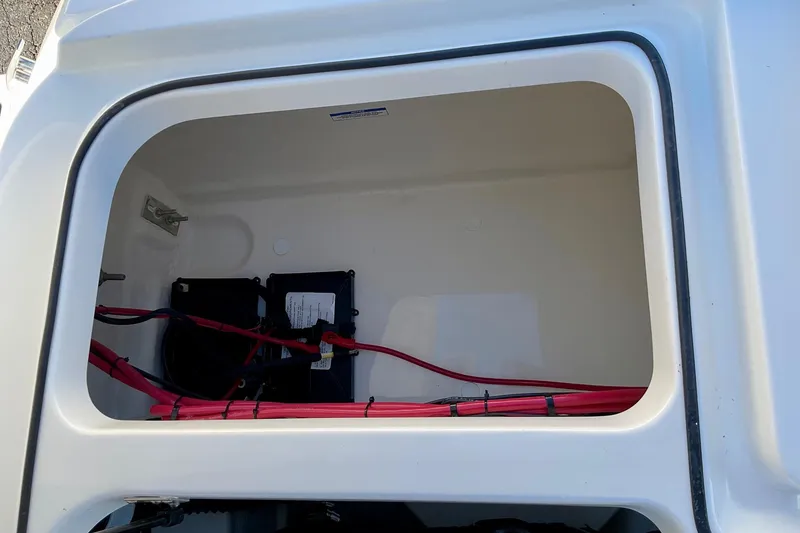 Slide: The Image of 2026 Bayliner VR6 Bowrider I/O battery compartment with red cables and secure fittings. - 17