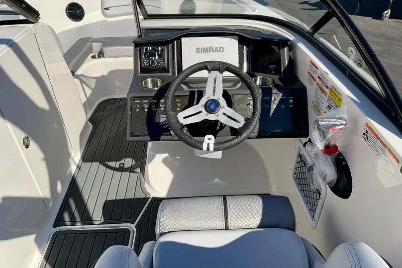 Slide: The Image of 2026 Bayliner VR6 Bowrider I/O cockpit with steering wheel and control panel. - 19