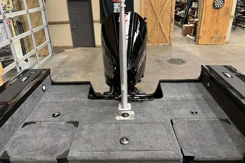 Slide: The Image of 2026 Tracker Targa V-19 Combo boat interior with motor, in a garage setting. - 6