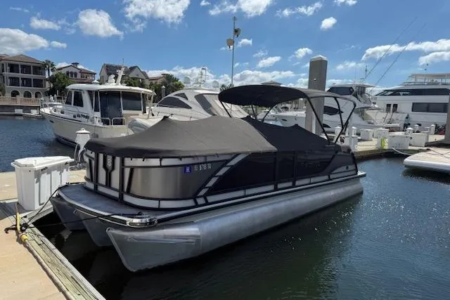 The Image of 2021 Godfrey Monaco 255 SFL pontoon boat docked at marina under blue sky. - 0