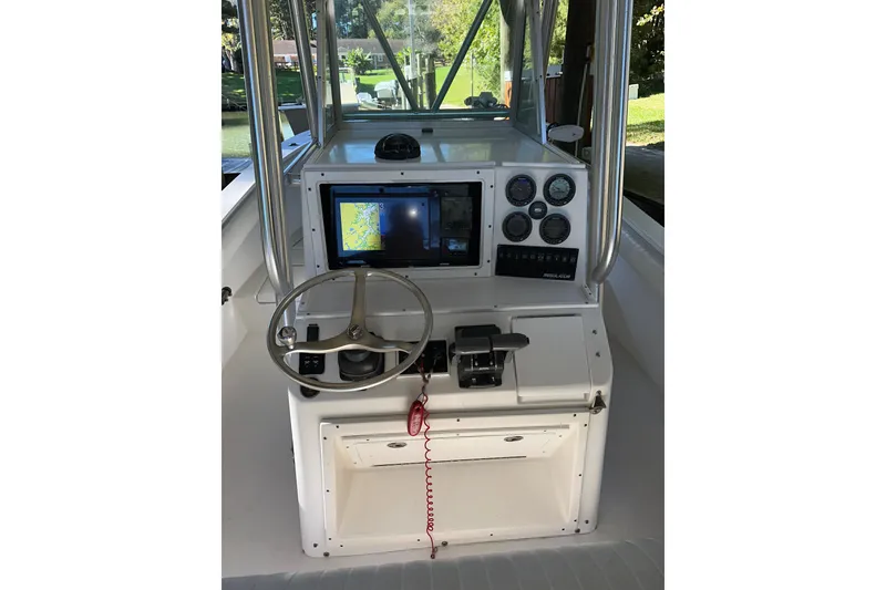 Slide: The Image of 2005 Regulator 26 Center Console boat dashboard with steering wheel and navigation system. - 11