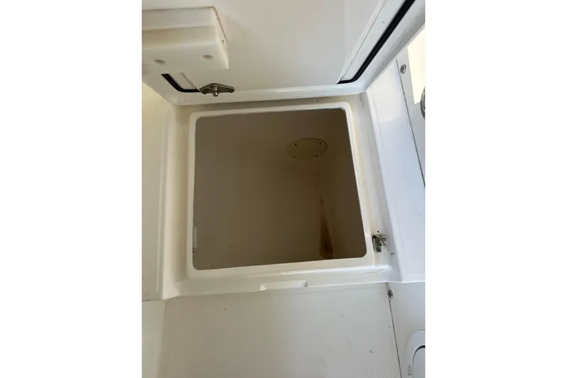 Slide: The Image of Open storage compartment on a 2005 Regulator 26 Center Console boat. - 18