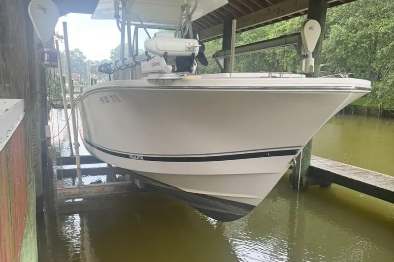 Slide: The Image of 2005 Regulator 26 Center Console boat docked in a covered marina. - 26