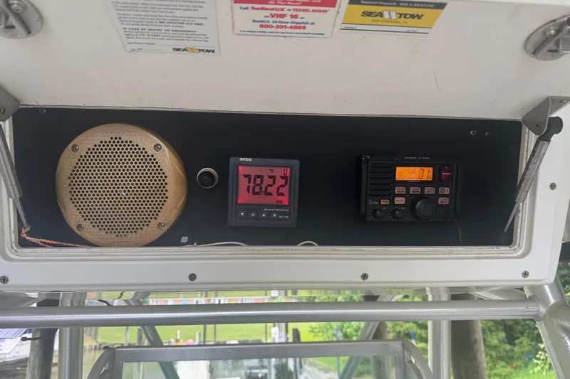 Slide: The Image of 2005 Regulator 26 Center Console dashboard with temperature gauge and radio equipment. - 27