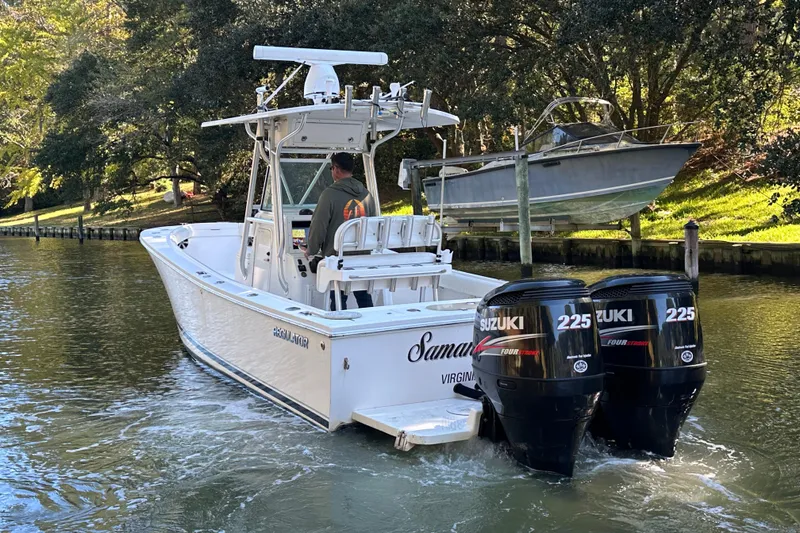 Slide: The Image of 2005 Regulator 26 Center Console boat with dual Suzuki 225 engines on a scenic waterway. - 6