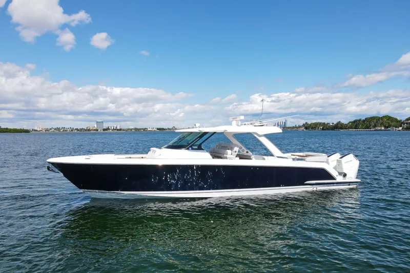 The Image of 2024 Tiara Yachts 43 LS luxury boat on calm water under a clear blue sky. - 1